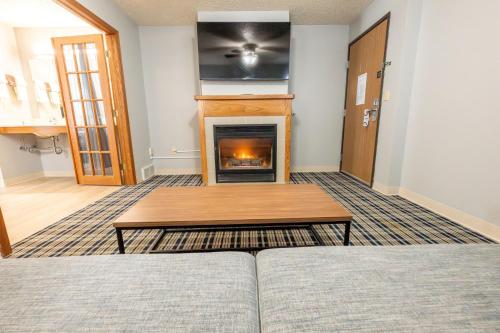 a living room with a couch and a fireplace at AmericInn by Wyndham Sturgeon Bay in Sturgeon Bay