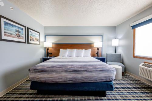 a hotel room with a large bed and a window at AmericInn by Wyndham Sturgeon Bay in Sturgeon Bay
