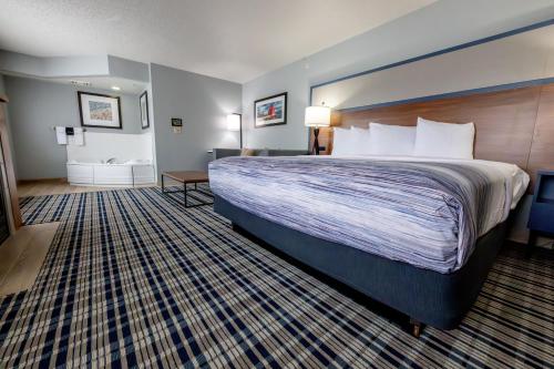 a hotel room with a large bed and a bathroom at AmericInn by Wyndham Sturgeon Bay in Sturgeon Bay