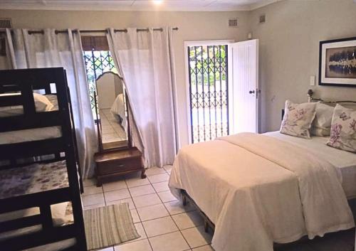 un dormitorio con una cama y un espejo en Zinkwazi Beach Access, en Zinkwazi Beach