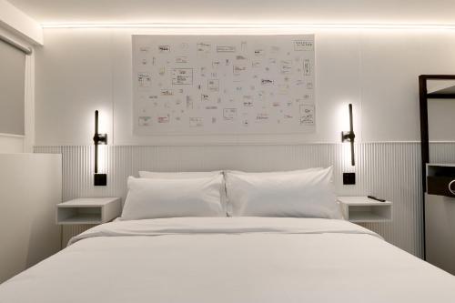 a bedroom with a large white bed with two lamps at Casa Guogu by AmazINN Places 3f in Panama City