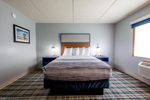 a hotel room with a large bed with two lamps at AmericInn by Wyndham Sturgeon Bay in Sturgeon Bay