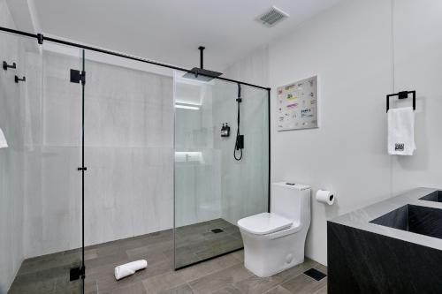 a bathroom with a toilet and a glass shower at Casa Guogu by AmazINN Places 3f in Panama City