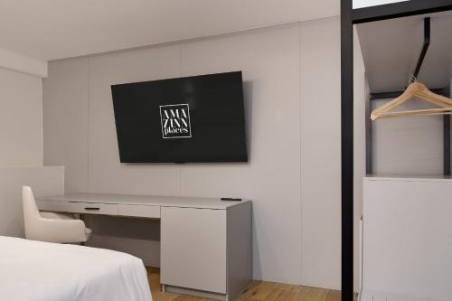a bedroom with a desk and a tv on a wall at Casa Guogu by AmazINN Places 3f in Panama City
