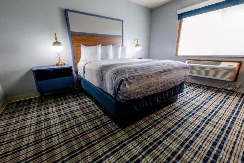 a hotel room with a bed and a large window at AmericInn by Wyndham Sturgeon Bay in Sturgeon Bay