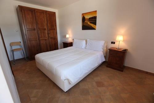 a bedroom with a large white bed and two night stands at Agriturismo Lapone in Orvieto