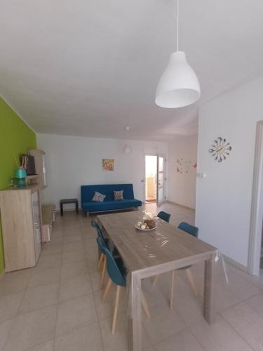 a living room with a table and a blue couch at Respiro di Mare in Ginosa Marina