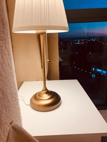 a lamp sitting on a table next to a window at Angel Heights in Croydon