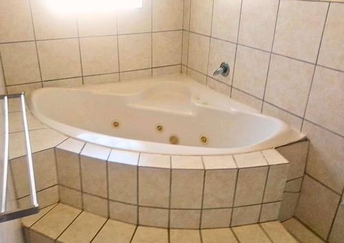 y baño con bañera y pared de azulejos. en Zinkwazi Beach Access, en Zinkwazi Beach