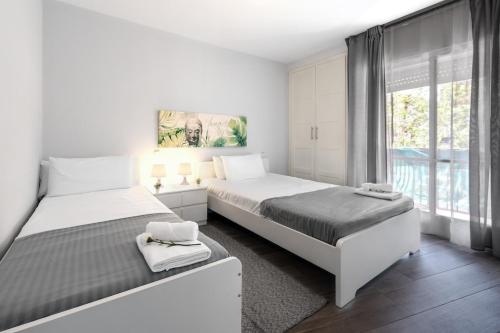 Un dormitorio blanco con dos camas y una ventana. en Maravilloso piso en Getafe, Madrid, en Getafe