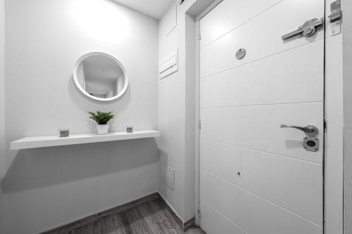 Un baño blanco con lavabo y espejo. en Maravilloso piso en Getafe, Madrid, en Getafe