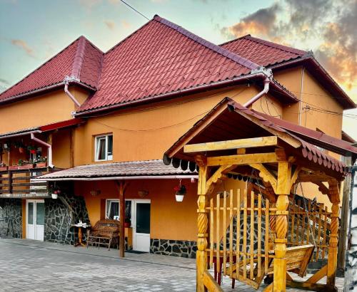 a house with a wooden gazebo in front of it at Pensiunea Brezu in Sighetu Marmaţiei