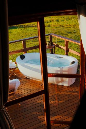 a bath tub sitting on the deck of a house at Chalé Refúgio da Coruja in Miracatu