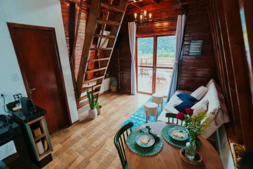 un salon avec une table et un canapé dans l'établissement Chalé Refúgio da Coruja, à Miracatu