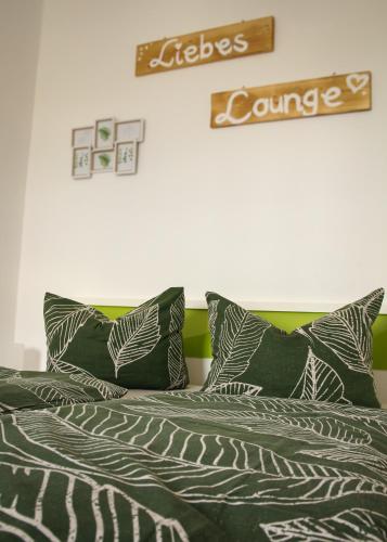 a bed with green and white pillows on it at Ferienwohnung Altstadtstube in Annaberg-Buchholz
