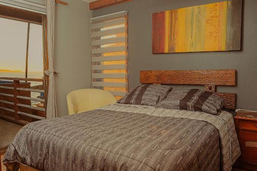 a bedroom with a bed and a view of the ocean at Cabañas Bordemar Habitaciones para 2 y 3, Cabañas para 4 y 5 huéspedes in Tomé