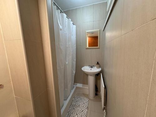 a small bathroom with a sink and a shower at Sweet night in London