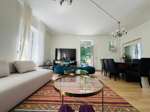 a living room with a couch and a table at Appartement de luxe plein centre in Divonne-les-Bains