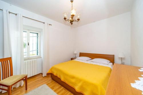 una camera con letto giallo e lampadario a braccio di Apartment Vinka near the beach a Postira (Postire)