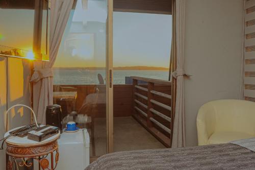 a bedroom with a bed and a view of the ocean at Cabañas Bordemar Habitaciones para 2 y 3, Cabañas para 4 y 5 huéspedes in Tomé