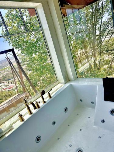 a bathroom with a bath tub in front of a window at Vintoca Luxury Honeymoon Suite Farm Retreat in Oceanside