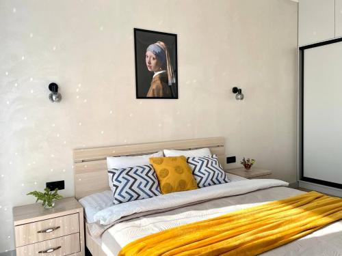 a bedroom with a bed and a picture on the wall at Уютные Апартаменты 1 Минута от Станции Метро in Almaty