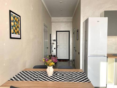a kitchen with a vase of flowers on a table at Уютные Апартаменты 1 Минута от Станции Метро in Almaty