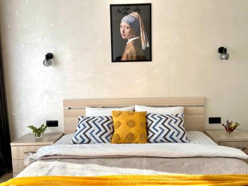 a bedroom with a bed with a painting of a woman at Уютные Апартаменты 1 Минута от Станции Метро in Almaty