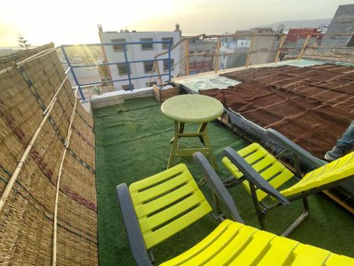 a patio with two chairs and a table on a roof at Heaven Surf & Soul in Tamraght Ouzdar