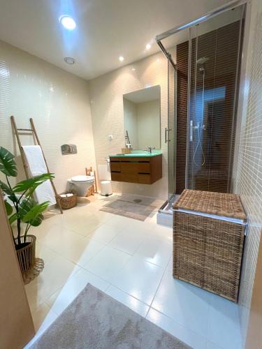 a bathroom with a shower and a sink and a toilet at Casa Custodio in Olhão