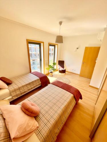 two beds in a room with a window at Casa Custodio in Olhão