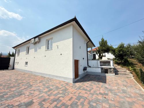 a large white building with a brick driveway at Countriside Holiday Villa in Kovashicë