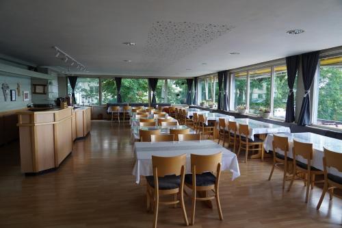 a row of tables and chairs in a restaurant at Alpina Löwen Hotel in Sankt Märgen