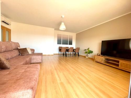 a living room with a couch and a flat screen tv at Casa Custodio in Olhão