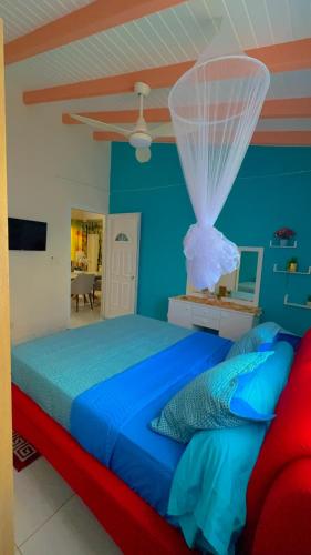 a blue bedroom with a bed with a net at Secrète Paradise in Capesterre-Belle-Eau