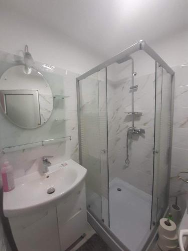 a bathroom with a shower and a sink and a mirror at Pensiunea Brezu in Sighetu Marmaţiei