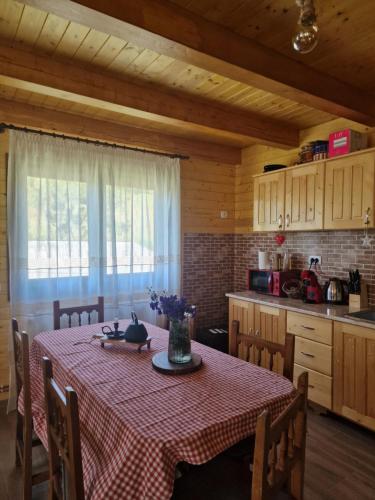 a kitchen with a table with a red and white table cloth at Cabana Saloc in Dămuc