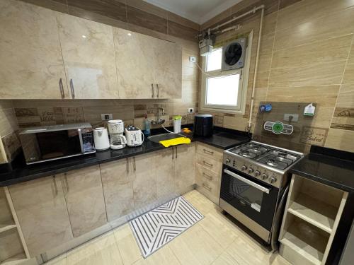 a small kitchen with a stove and a microwave at Cozy Super Furnished Fully equipped and decorated in 6th Of October