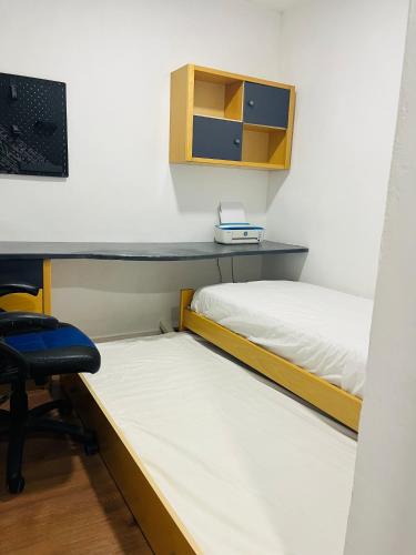 two beds in a room with a desk and a chair at Casa Leo in Almería