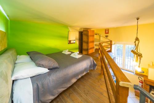 a bedroom with a bed with a green wall at E-Home in Volla