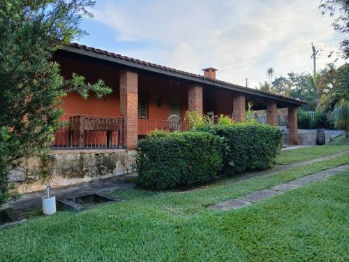 a brick house with bushes in front of it at Chácara Recanto in Jarinu