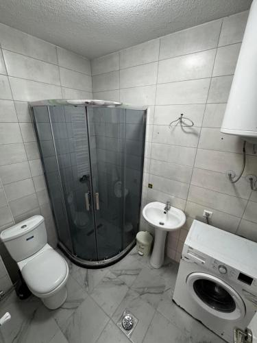 a bathroom with a shower and a toilet and a sink at Nest Apartments - FK Commodity in Kosovo Polje