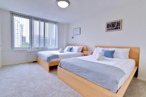 a bedroom with two beds and a large window at Stylish Apartment Close to National Landing in Arlington
