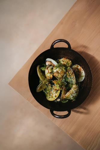 a bowl of shrimp and vegetables on a table at MIRA Earth Studios in Valle de Guadalupe