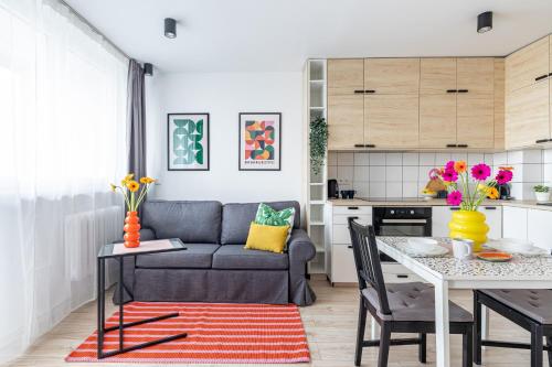 a living room with a couch and a table at Markowska by VAYA STAYS in Warsaw
