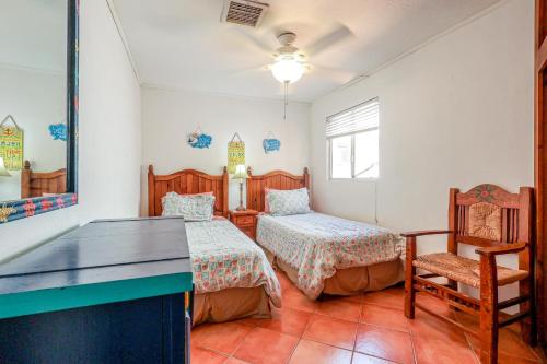 a bedroom with two beds and a desk and a chair at Mariposa in Puerto Peñasco
