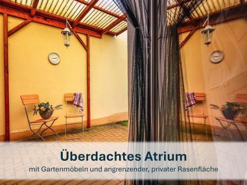 une chambre avec 2 chaises et des réveils sur le mur dans l'établissement Villa Beethoven mit Ladestation, à Zinnowitz