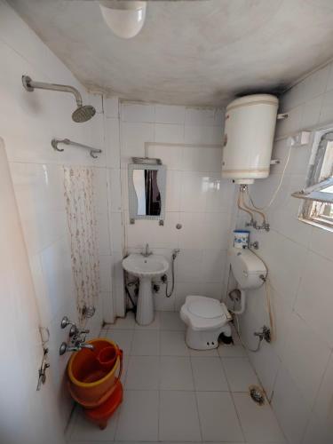a small bathroom with a toilet and a sink at Lake Boulevard Guest House in Srinagar