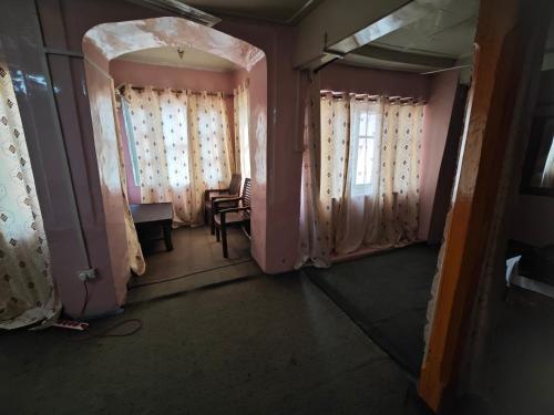 an empty room with curtains and a table and a window at Lake Boulevard Guest House in Srinagar