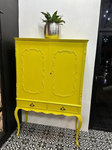 a yellow cabinet with a potted plant on top of it at Maison Norelle at Isivuno House in Gillitts